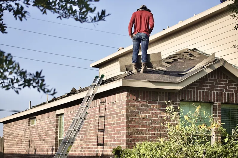Professional roofer working on a residential roof in Danvers Center